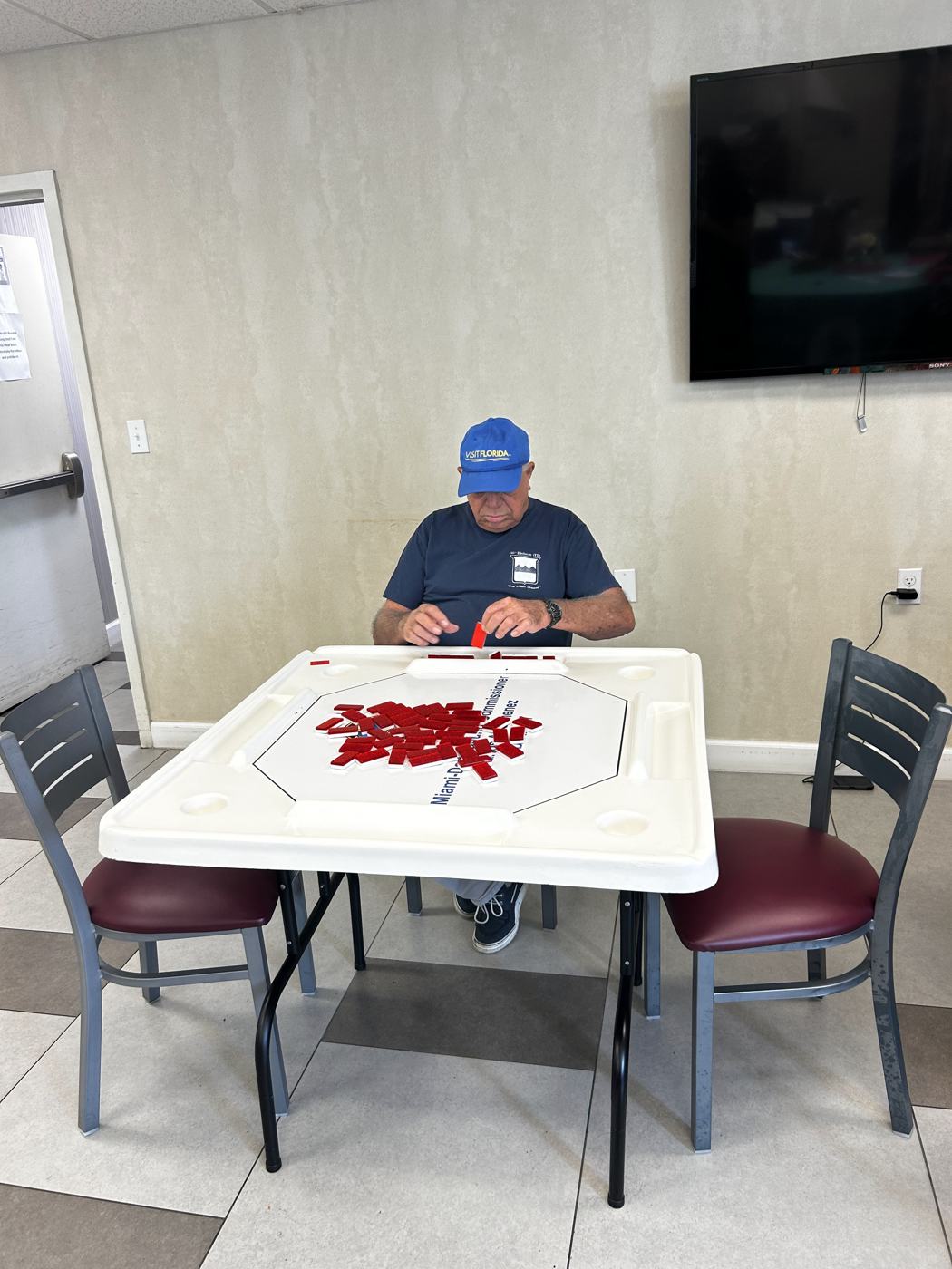 A senior arranging red petals on a table