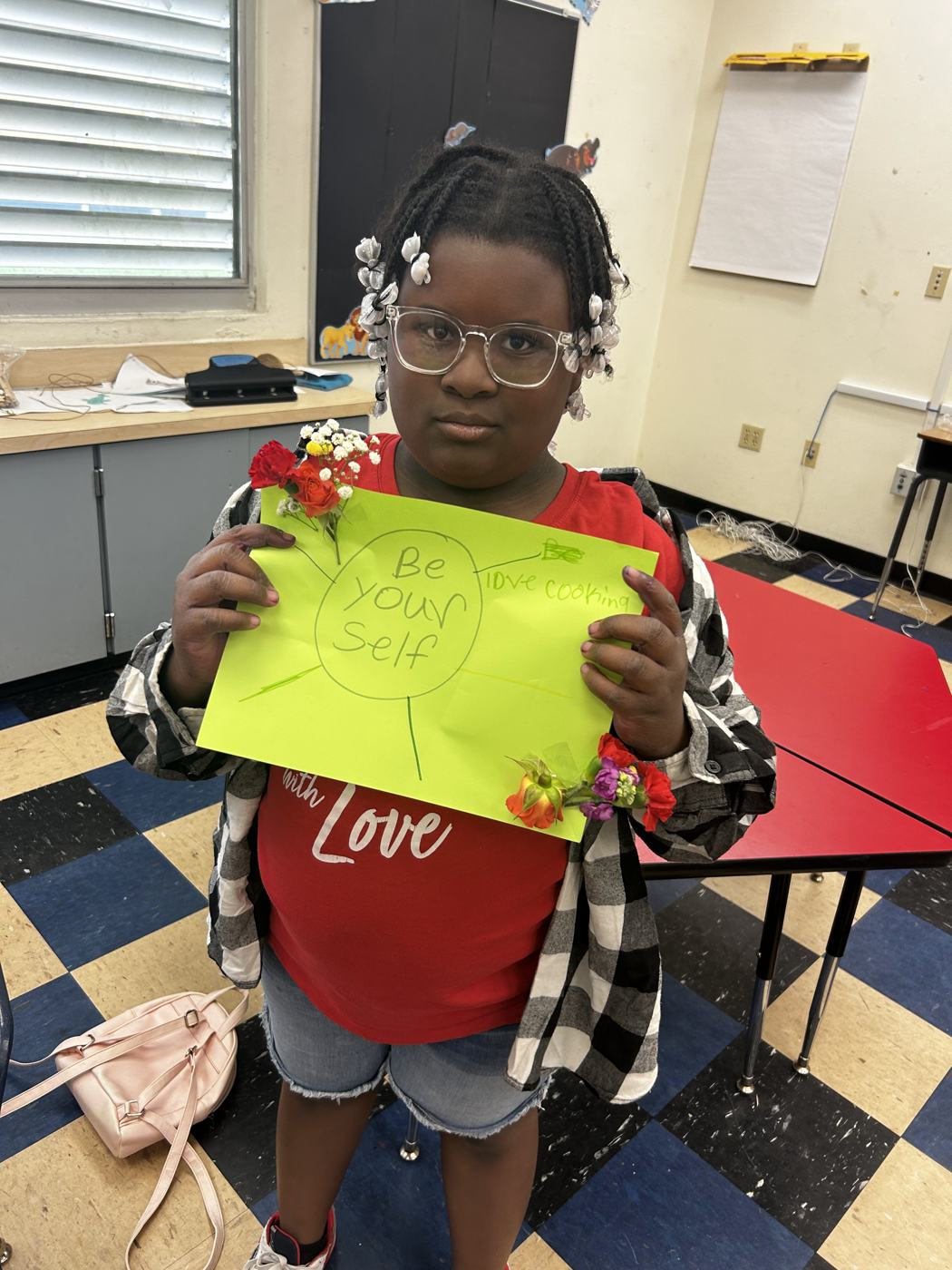 A student holding a yellow card reading Be Yourself