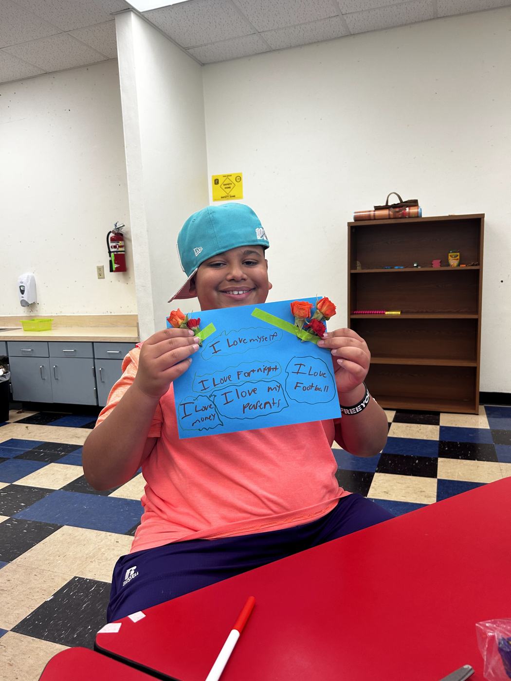 A student holding a blue card decorated with flowers