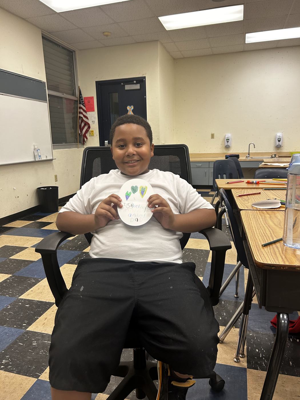 A student holding his paper plate artwork