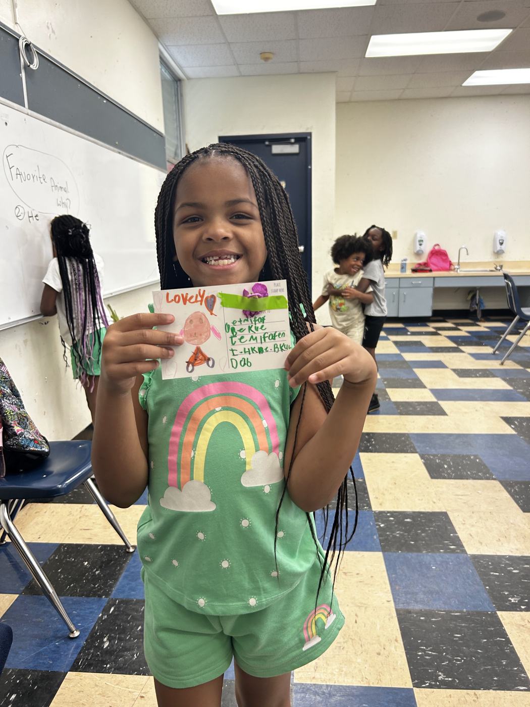 A smiling student holding her flower card